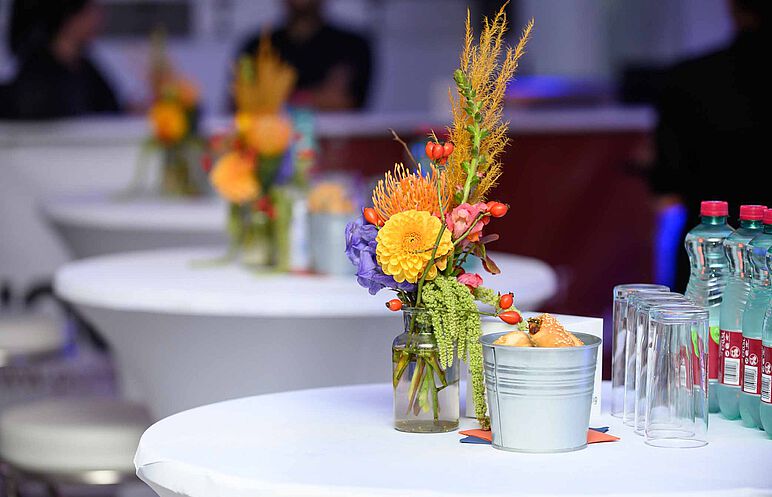 Bild: Tischdekoration mit Blumen, Würfel und Snacks