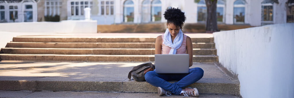 Frau mit Laptop absolviert Fernstudium auf Stufen
